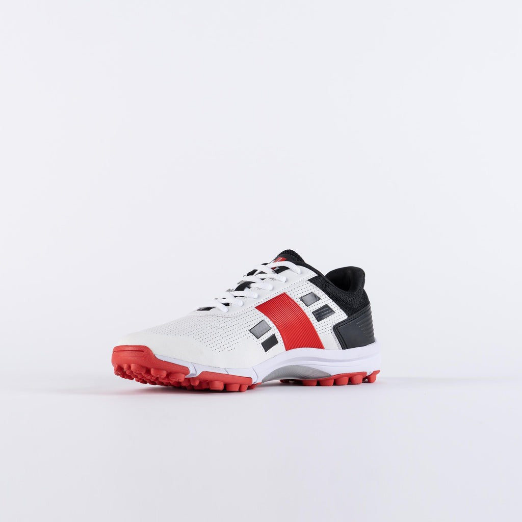 White sports shoe with red soles Gray Nicolls Velocity 4.0 rubber sole shoes for cricket net practice