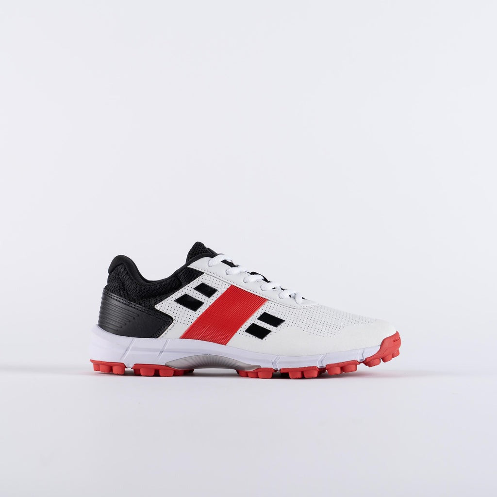 A pair of white cricket shoes with red and black accents, featuring a rubber outsole and a mesh upper Gray Nicolls Velocity 4.0 rubber cricket shoes with lightweight design