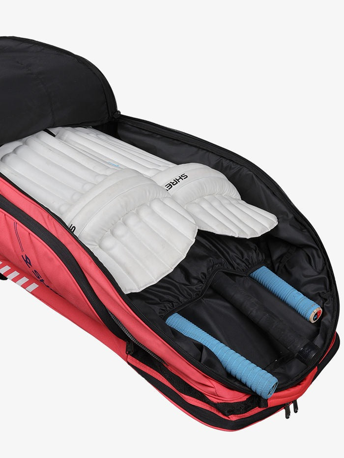 Open backpack with sleeping pad and rolled-up Open Shrey Legacy Duffle 120 wheelie cricket kit bag showing main compartment