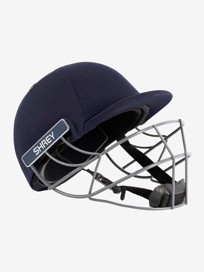 Navy blue cricket helmet with a metal grill Side profile of the Shrey Performance helmet showing the impact shell